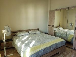een slaapkamer met een groot bed en een ventilator bij Big Seafront Apartment in Saida Lebanon in Saïda