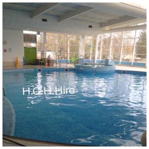 a large swimming pool with a tub in a building at Haven Haggerston castle caravan hire in Cheswick
