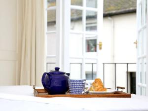 a tray with a blue tea pot and a plate of food at North Laine Cottage in Brighton & Hove