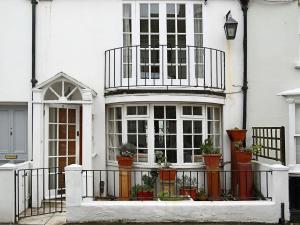 a white house with potted plants on a balcony at North Laine Cottage in Brighton & Hove