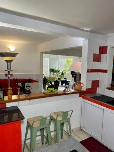 eine Küche mit grünen Stühlen und einer Theke mit einer Arbeitsplatte in der Unterkunft Besson, maison de caractere in Le Gosier