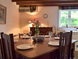 a dining room table with glasses and a vase of flowers at Y Bwthyn in Cilgwm