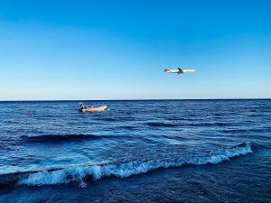 a small boat and a plane in the ocean at GRACE HOUSE in Pyla