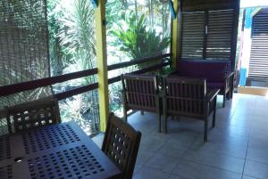 a balcony with benches and a view of the jungle at IWANA en Guadeloupe in Bouillante