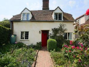 a white house with a red door at Box Cottage in Eastling