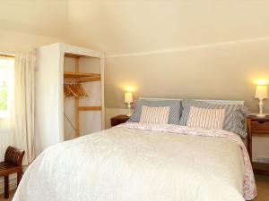um quarto com uma grande cama branca e 2 almofadas em Box Cottage em Eastling