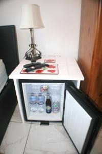 a small refrigerator with drinks and a lamp on a table at Woodside Lodge in Thurstaston