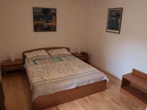 a bedroom with a bed with two night stands and two pictures at House Vodice in Vodice