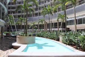 a swimming pool in front of a building with palm trees at 2 Sleeper SEA VIEW Apartments - Near MSC Cruise Terminal in Durban