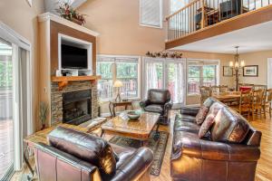 a living room with leather furniture and a fireplace at Alpine Retreat in Helen