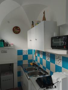 a kitchen with a sink and a microwave at Nuida Casa Vacanze in Capri