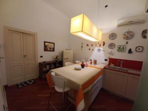 uma cozinha com uma mesa com cadeiras e um lavatório em Interno10 em Bari