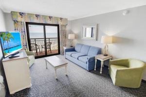 a living room with a blue couch and a television at Oceanfront 3BR/2BA, Ocean Reef, Waterpark in Myrtle Beach