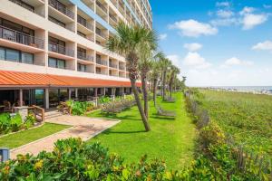 a hotel with palm trees next to the beach at Oceanfront 3BR/2BA, Ocean Reef, Waterpark in Myrtle Beach