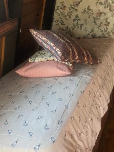 a bed with two pillows on top of it at Habitación Boutique in Villa Alsina