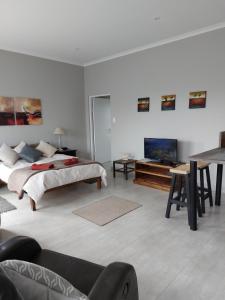 a white room with a bed and a tv at Silver Oaks Airbnb in Langebaan