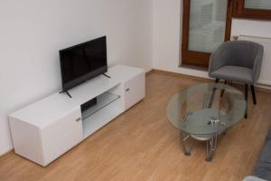 a living room with a tv and a glass table at Apartman Vesna in Doboj