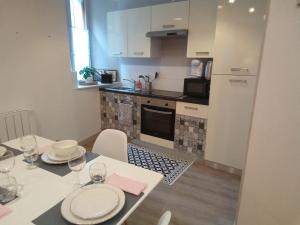 a kitchen with a table and a white table and chairs at Coeur de ville cosy in Morlaix +1 photo