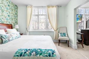 a bedroom with a bed and a chair and a window at Southbank TOWN HOUSE in Torquay