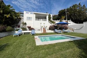 a house with a swimming pool in the yard at Villa on Camps Bay Drive in Cape Town