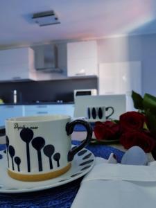 una taza de café sentada en una mesa con rosas en Casa Vacanza "Marinella", en Sulmona