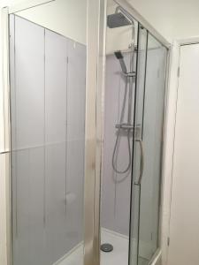 a shower with a glass door in a bathroom at Simla Bungalow, Tetney in Tetney