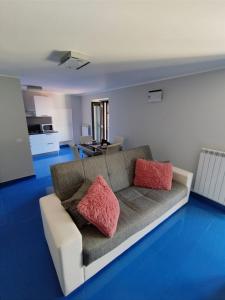 un soggiorno con divano e 2 cuscini rosa di Casa Vacanza "Marinella" a Sulmona