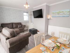 a living room with a couch and a table at Seaside Retreat in Prestatyn