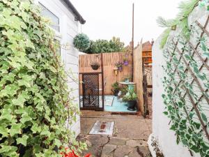 an entrance to a garden with a wooden fence at Bumble Bee Cottage in Faversham