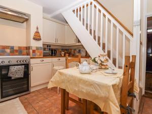 una cocina con una mesa con una tetera. en Bumble Bee Cottage en Faversham