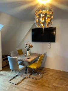 a dining room with a table and chairs and a chandelier at LevelUp 3 Living Graz m. SelfCheckIn in Graz