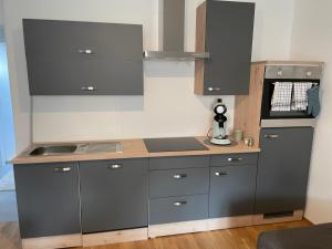 a kitchen with gray cabinets and a counter top at LevelUp 3 Living Graz m. SelfCheckIn in Graz