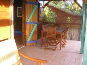 un patio con tavolo e sedie in legno di GWAN THAZAR en Guadeloupe a Bouillante