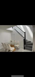 a white room with white chairs and a staircase at Perfect 4 bedroom 2 bathroom Home in Edinburgh