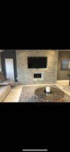 a living room with a fireplace and a tv at Perfect 4 bedroom 2 bathroom Home in Edinburgh