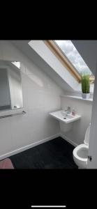 uma casa de banho com um lavatório, um WC e uma janela. em Perfect 4 bedroom 2 bathroom Home em Edimburgo
