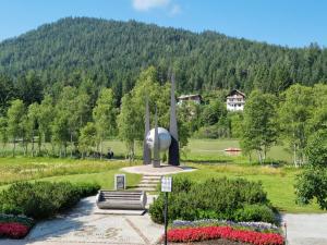 a statue in a park with a mountain in the background at Wohlfühl-Appartement Bergsee FAMILY - am Wildsee - SUP und Schlitten for free in Seefeld in Tirol