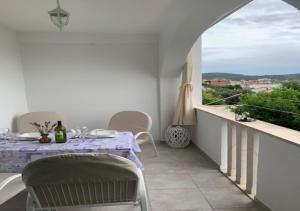 a dining table and chairs on a balcony with a window at Holiday Apartments Lučić - Feels like Home, away from Home in Ražanj