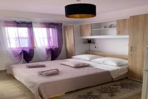 a bedroom with a large bed with two towels on it at Holiday Apartments Lučić - Feels like Home, away from Home in Ražanj