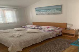 a bedroom with a bed with two towels on it at Holiday Apartments Lučić - Feels like Home, away from Home in Ražanj