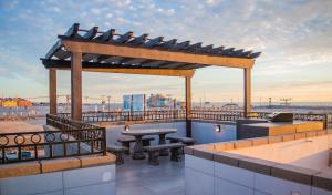 a rooftop patio with a picnic table and a pergola at Playas Hotel Suites in Puerto Peñasco