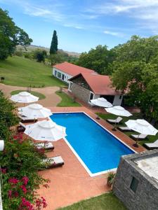 una piscina con ombrelloni bianchi e una casa di Estancia Turística San Pedro de Timote a Reboledo