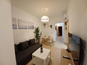 sala de estar con sofá y mesa en For You Rentals Infantas Gran Via INF2E, en Madrid