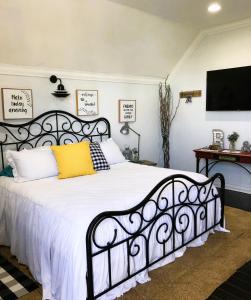 una camera da letto con un letto bianco e nero con un cuscino giallo di Days Gone Bye a Nassau