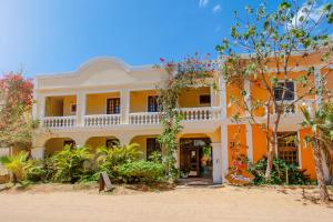 un edificio naranja y blanco con árboles y plantas en Hotel Villa Beija Flor, en Jericoacoara