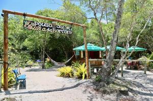 a park with a hammock and a sign that readsossos wildabacteria at Villa da Barca in Ilha de Boipeba