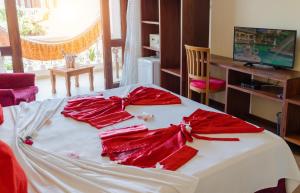Una cama con arcos rojos encima. en Hotel Villa Beija Flor en Jericoacoara