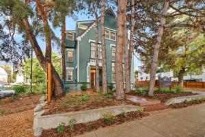 uma casa verde com árvores em frente em Flora House Denver em Denver