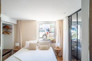 a bedroom with a white bed and a window at Charmant Studio paisible dans le Centre du Village in Échenevex