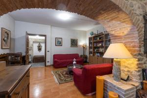 un soggiorno con divano rosso e muro di mattoni di Il Ducato a Cortona